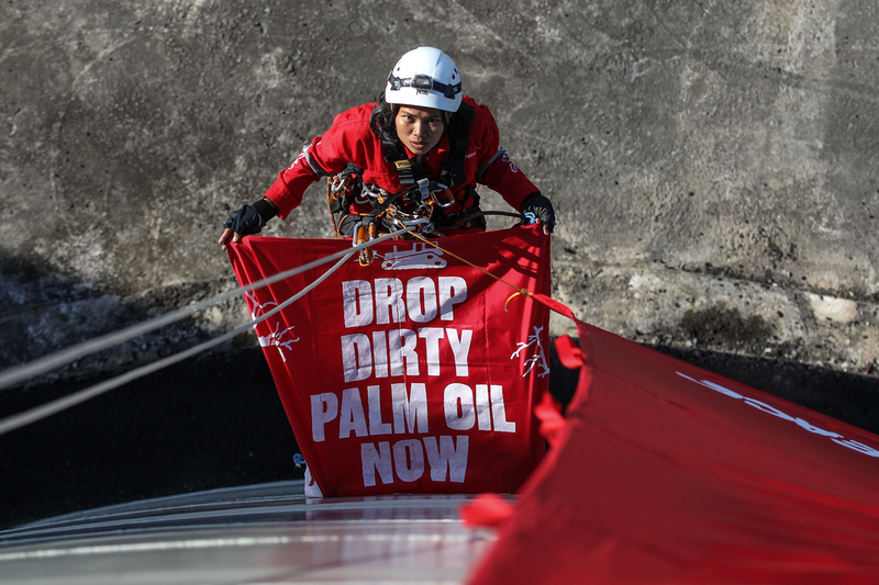An activist scaling the refinery (© Dhemas Reviyanto / Greenpeace)