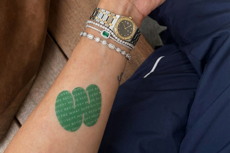A woman's arm with a What Supp Co patch